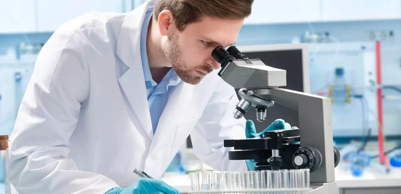 Profissional ajustando o microscópio para reduzir a fadiga ocular